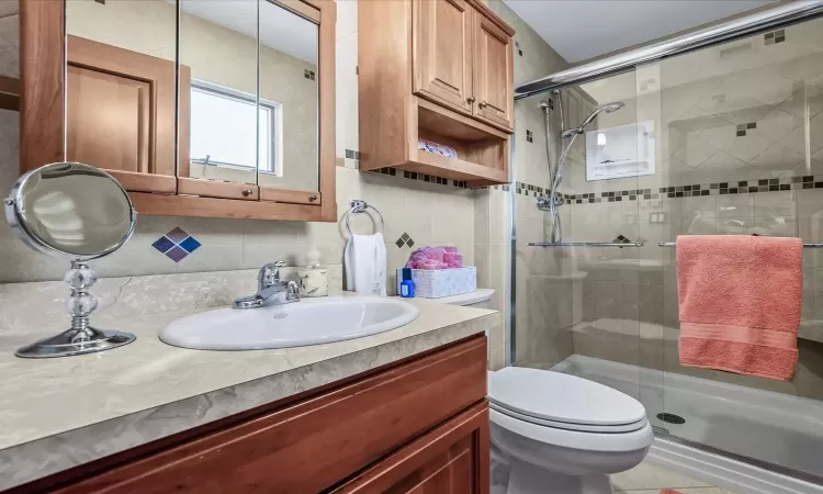 Bedroom with a baseboard heating unit, an inviting chandelier, ensuite bathroom, and access to outside