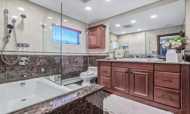 Bathroom featuring toilet, vanity, backsplash, and an enclosed shower