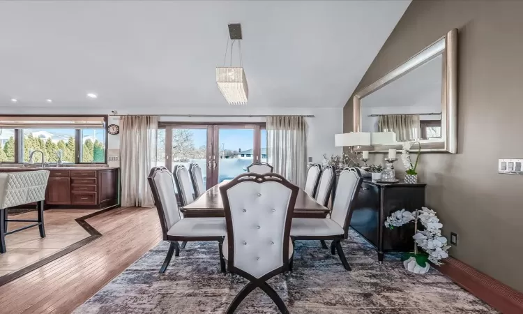 Kitchen featuring a large island, a breakfast bar area, stainless steel appliances, hanging light fixtures, and light stone counters