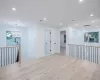 Spare room with light wood-type flooring, an inviting chandelier, and a wealth of natural light