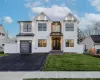 Modern farmhouse style home featuring a front lawn and a garage