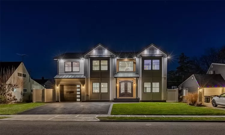 View of front of house featuring a garage and a yard