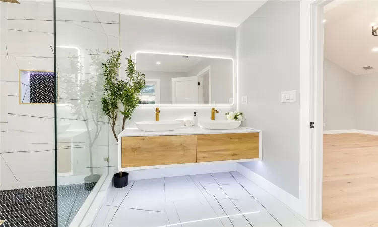 Bathroom with vanity and tiled shower