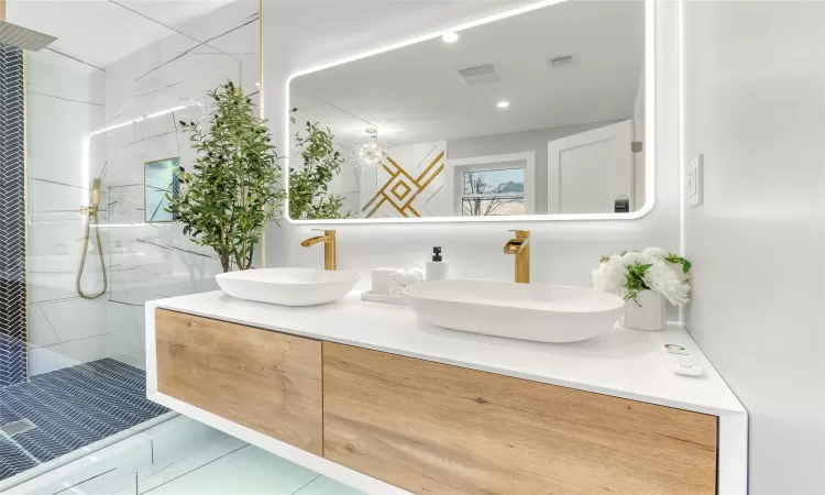 Bathroom with tiled shower and vanity