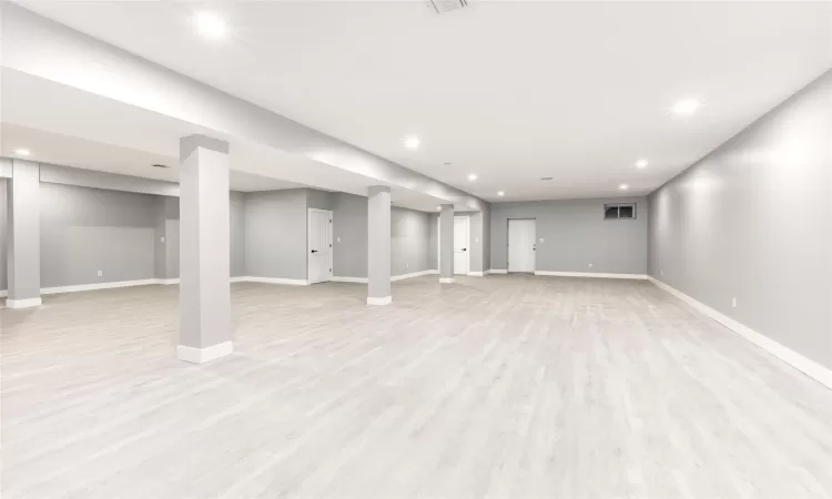 Basement with light hardwood / wood-style flooring