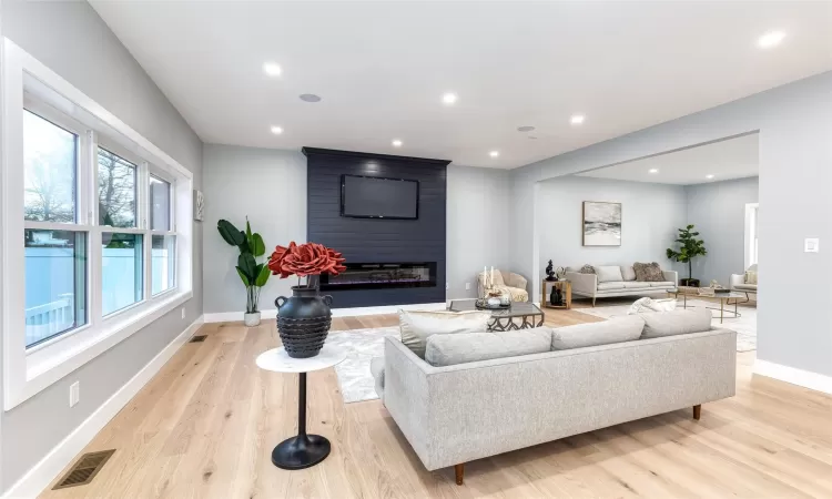 Living room featuring a large fireplace and light wood-type flooring