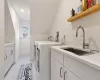 Laundry area with sink, light tile patterned flooring, independent washer and dryer, and cabinets