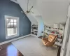 Living area with built in shelves, dark hardwood / wood-style floors, and lofted ceiling