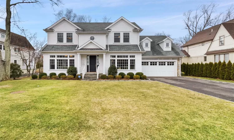 View of front of house featuring a front lawn and a garage