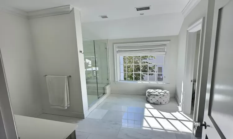 Bathroom featuring ornamental molding and an enclosed shower