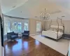 Bedroom featuring wood-type flooring, a notable chandelier, and vaulted ceiling