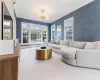 Living room with a chandelier, crown molding, and carpet flooring