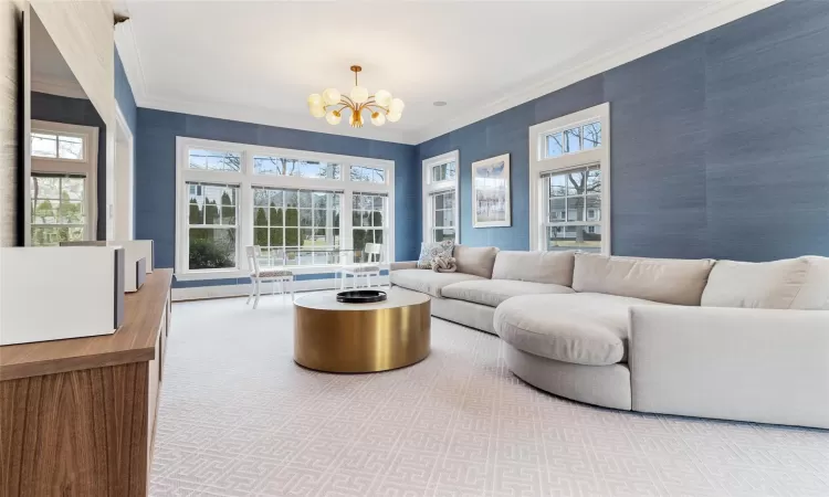 Living room with a chandelier, crown molding, and carpet flooring