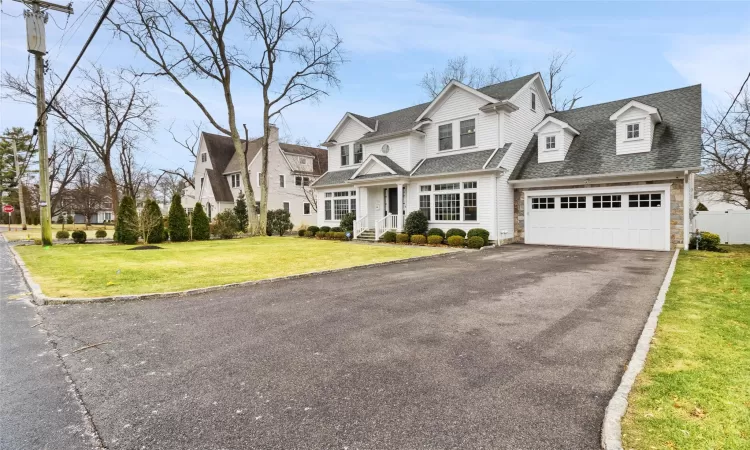 View of front of property with a garage and a front yard