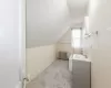 Bathroom featuring lofted ceiling, radiator, and vanity