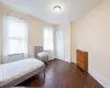 Bedroom featuring a closet, dark wood-type flooring, and radiator heating unit