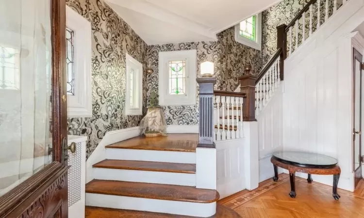 Stairway featuring parquet floors and crown molding