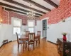 Dining space with light parquet floors, beamed ceiling, and an inviting chandelier