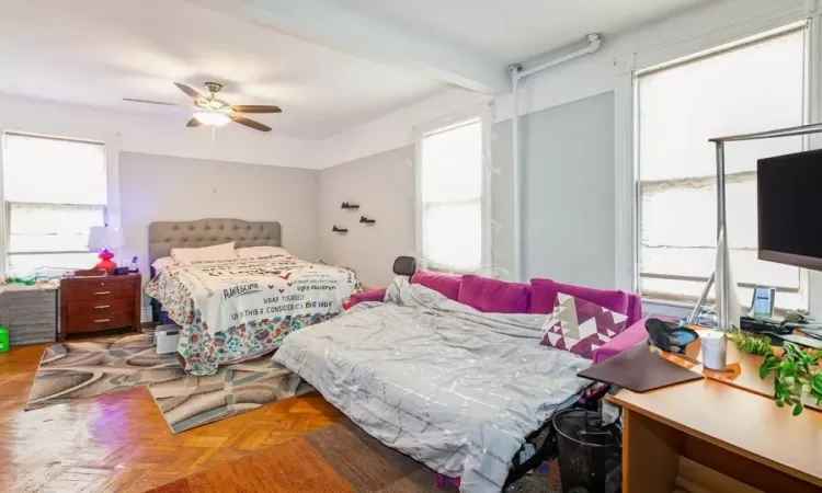 Bedroom featuring ceiling fan and parquet flooring