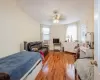 Bedroom featuring ceiling fan, cooling unit, multiple windows, and hardwood / wood-style floors