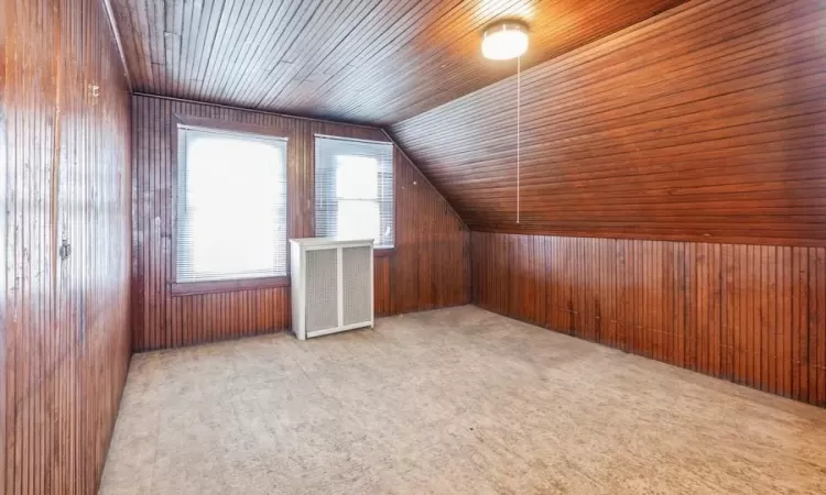 Bonus room featuring vaulted ceiling, wood ceiling, and wooden walls