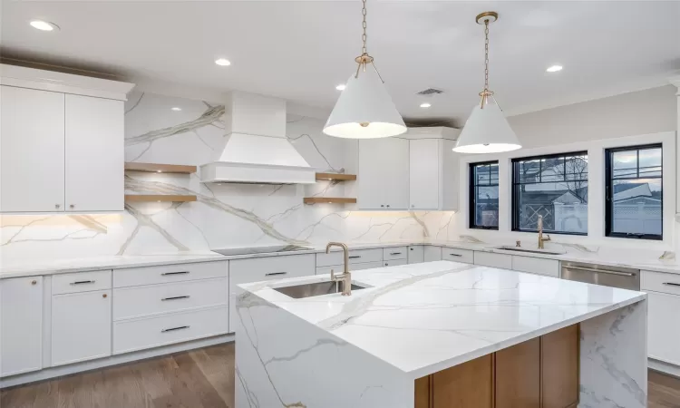 Kitchen featuring white cabinets and custom range hood