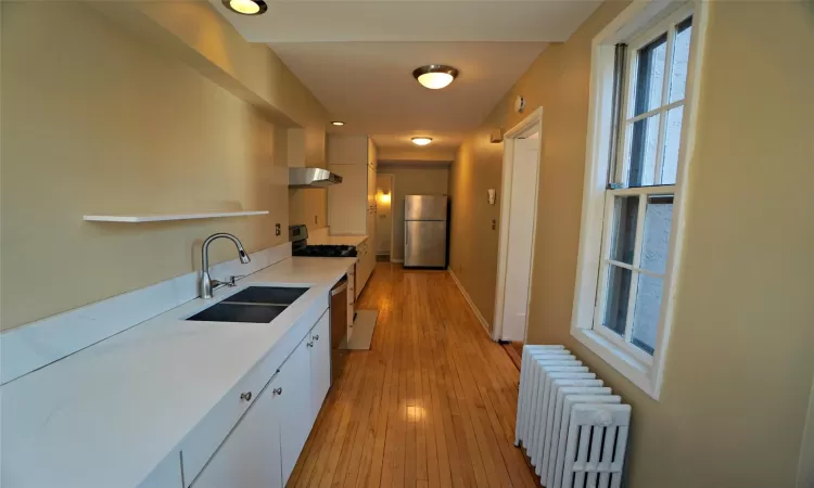 Kitchen featuring appliances with stainless steel finishes, white cabinets, and sink