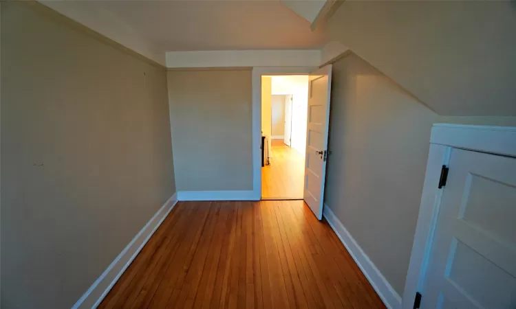 Walk in closet with dark hardwood / wood-style floors