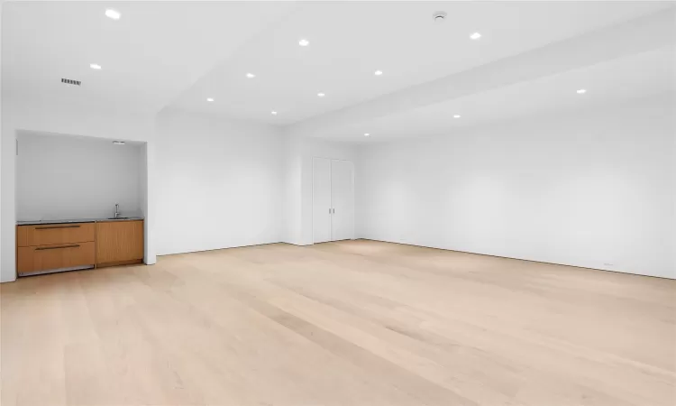 Unfurnished living room with light hardwood / wood-style flooring and sink