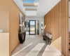 Hallway featuring wood walls, light hardwood / wood-style floors, and a skylight