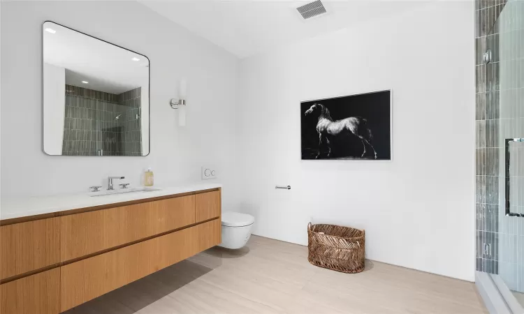 Bathroom with walk in shower, vanity, and toilet