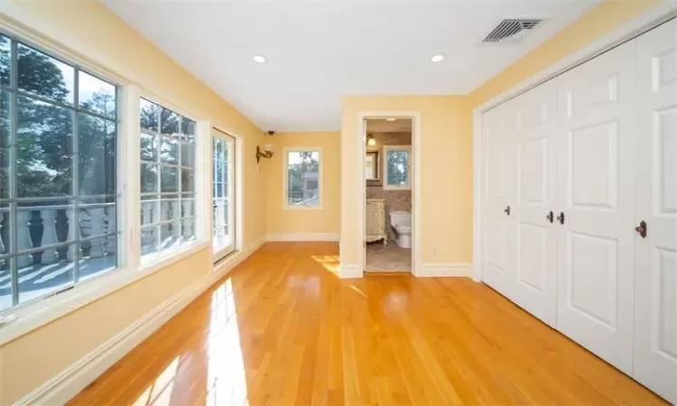 Bedroom with hardwood / wood-style floors and ensuite bathroom