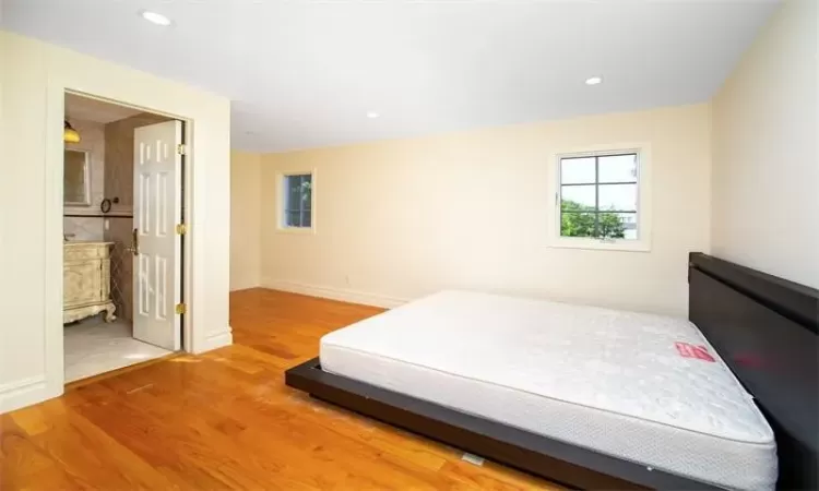 Bedroom featuring vaulted ceiling, french doors, hardwood / wood-style floors, and an inviting chandelier