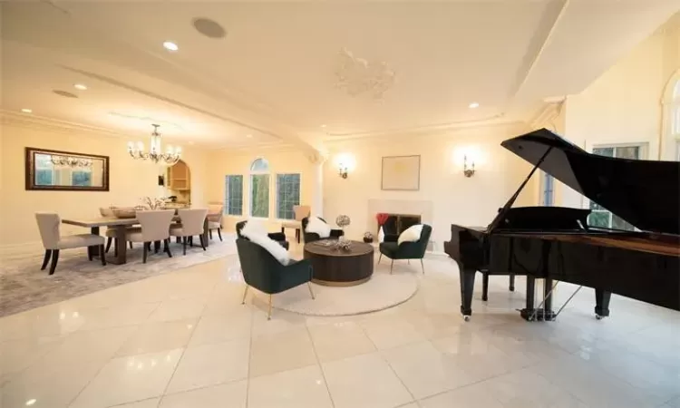 Staircase with a high ceiling, tile patterned floors, crown molding, and a notable chandelier