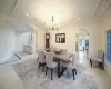 Dining area featuring a chandelier, light tile patterned floors, and ornamental molding