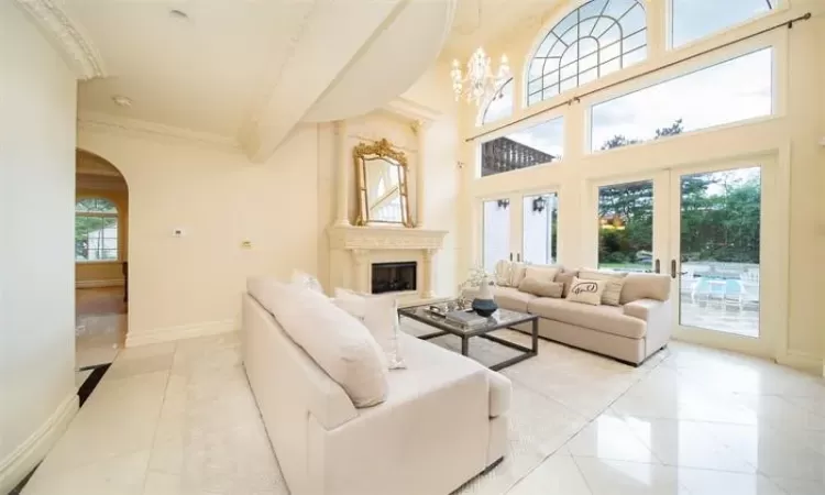 Living area featuring a chandelier, crown molding, and light tile patterned floors