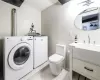 Laundry room with washer and clothes dryer, tile walls, and light tile patterned flooring