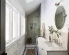 Bathroom featuring separate shower and tub, vanity, tile walls, vaulted ceiling with skylight, and tile patterned flooring