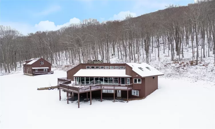 Snow covered property with a wooden deck