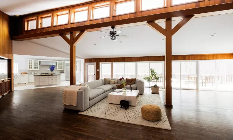 Living room with ceiling fan, wood-type flooring, and lofted ceiling