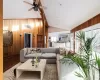 Living room with wood walls, light hardwood / wood-style flooring, lofted ceiling, and ceiling fan