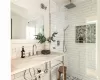 Bathroom with a tile shower, tasteful backsplash, and sink