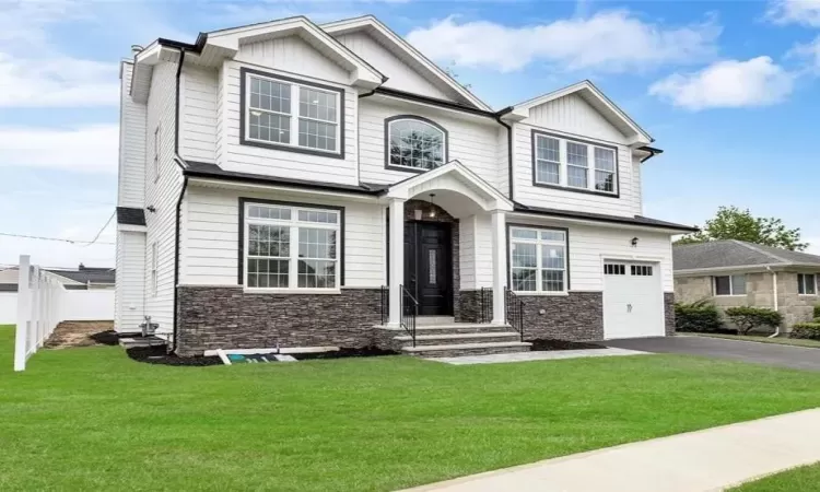 Craftsman house with a garage and a front lawn