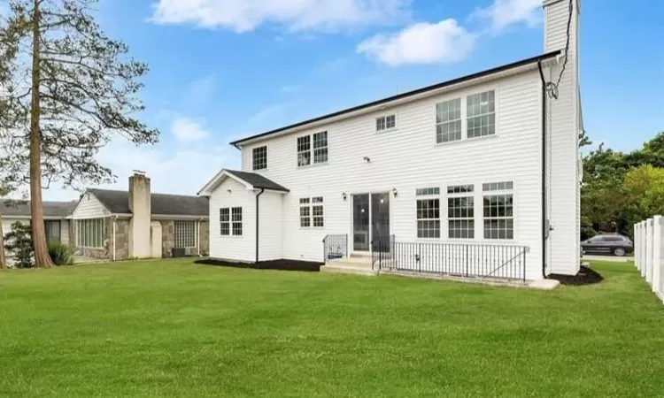 Rear view of property with a lawn