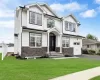 Craftsman house with a garage and a front lawn