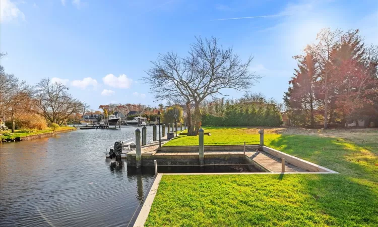 View of dock with a water view and a yard