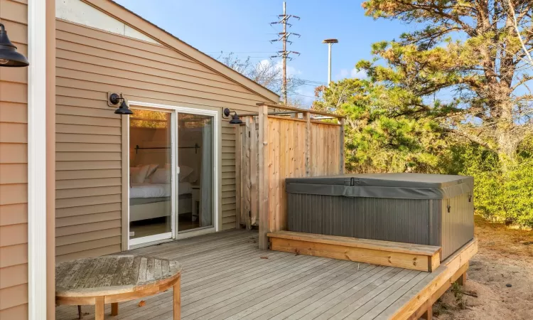 Deck with a hot tub and outdoor shower outside master suite.