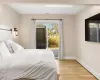 Bedroom featuring baseboard heating, multiple windows, and light hardwood / wood-style flooring