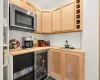 Kitchen pantry with sink, wood counters, beverage cooler, and light brown cabinets