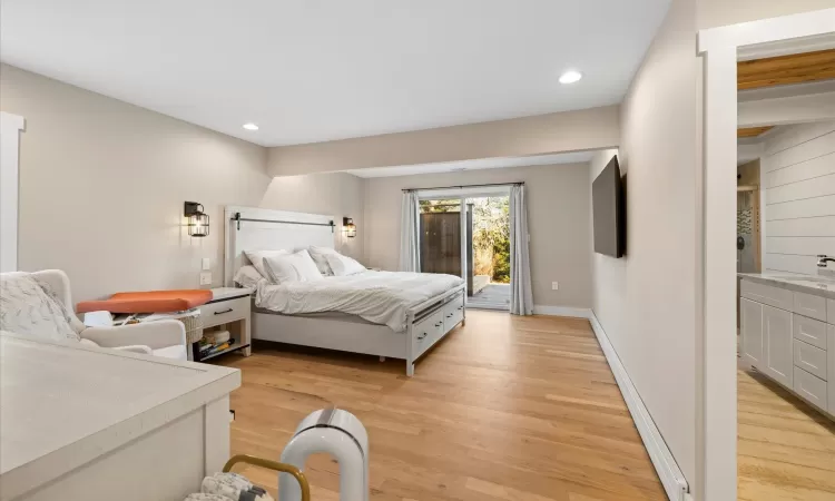 Bedroom featuring sink, light hardwood / wood-style floors, and access to outside